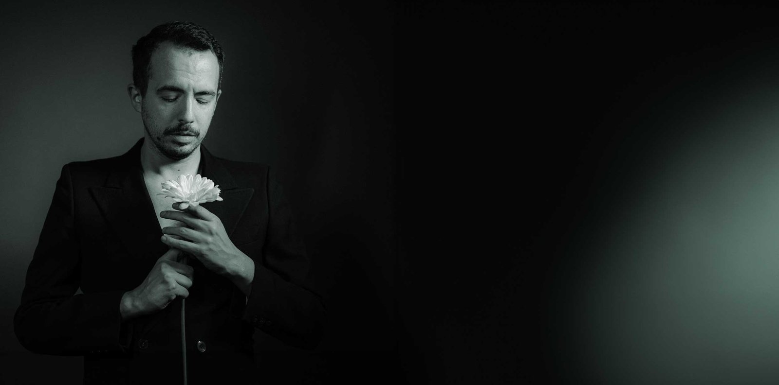 Gianluca Ercoli a occhi chiusi, con un fiore bianco stretto al petto